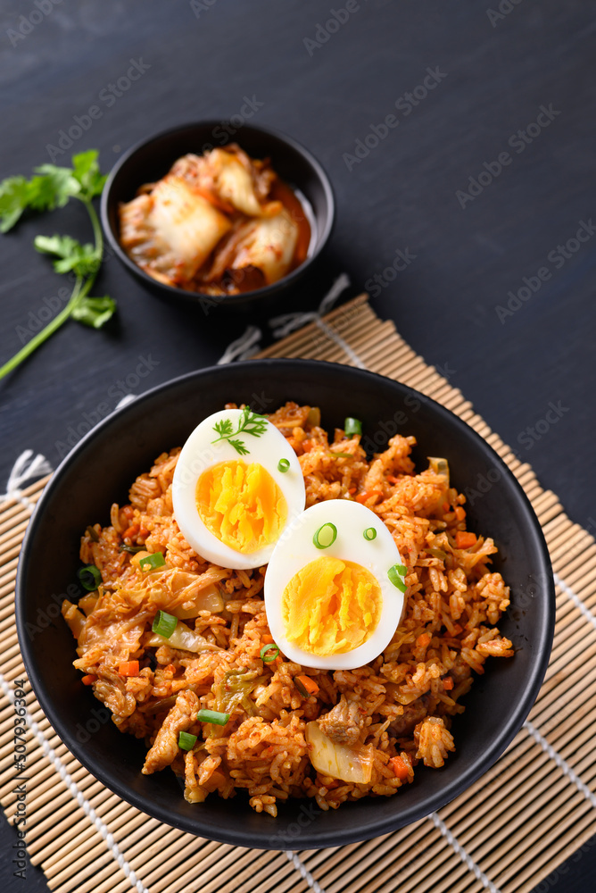 Korean kimchi fried rice with boiled egg on black background Stock