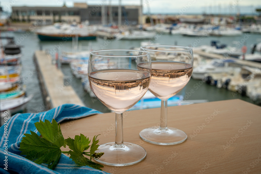 Rose wine in glasses served on outdoor terrace with view on old fisherman's harbour with colourful boats in Cassis, Provence, France Rose wine in glasses served on outdoor terrace with view on old fisherman's harbour with colourful boats in Cassis, Provence, France