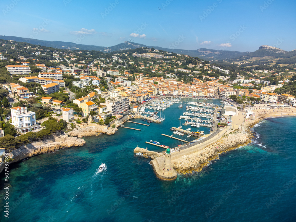 Fototapeta premium Panoramic aerial view on cliffs, blue sea, beach, houses, streets and old fisherman's harbour with lighthouse in Cassis, Provence, France