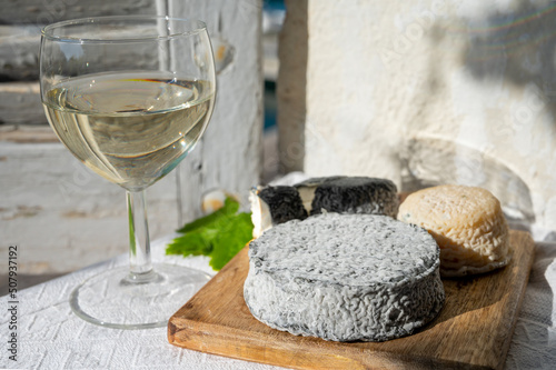 French goat cheeses crottin and selles-sur-cher served with view on boats in harbor of Cassis, Provence, France with glass of dry white wine
