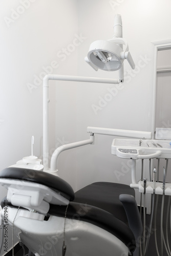 dental office interior equipped with dental chair, lamp and tools, professional objects in workplace, medicine