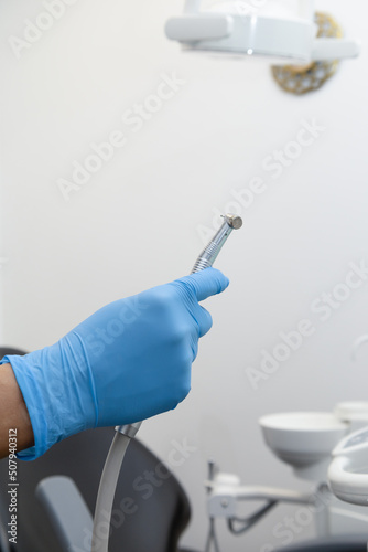 hand holding modern dental office tool, medical equipment in studio, wallpaper © Alejandro