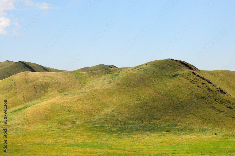 A range of high hills with a stone formation running along the top.