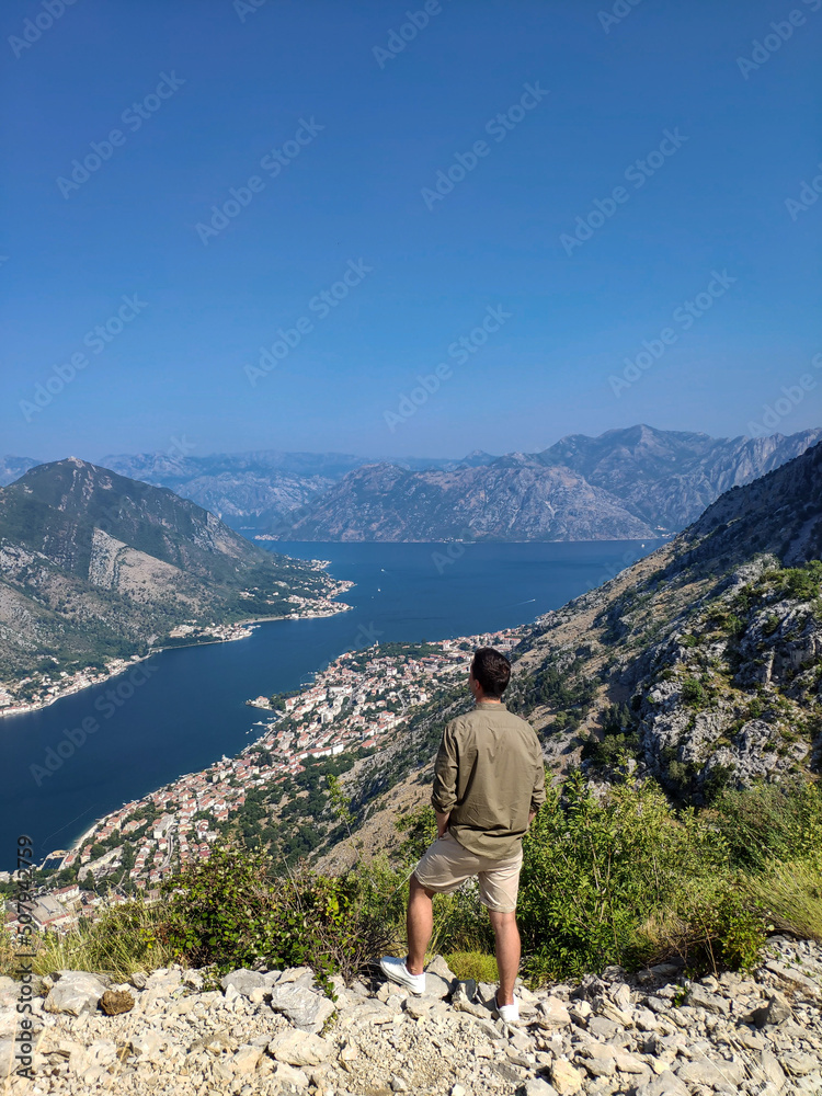 Man is standing and looking at Kotor bay from above in Kotor, Montenegro
