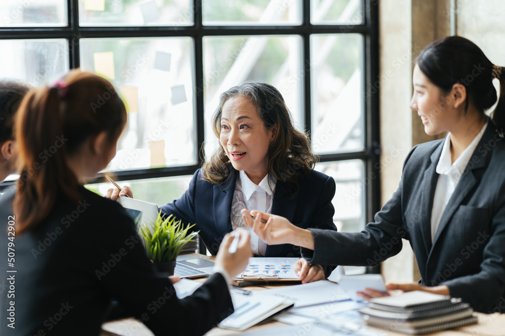 Asian business partners discussing documents and ideas at meeting, Successful business team sitting in office and planning work. Asian business partners discussing documents and ideas at meeting, Successful business team sitting in office and planning work.