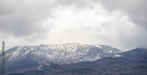 Snow-capped mountains against the background of the sky with clouds. © Prikhodko
