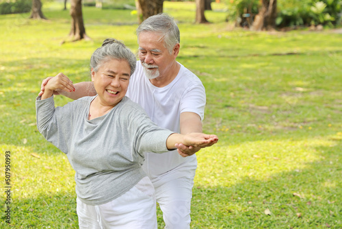 Asian senior couple practice yoga excercise, tai chi tranining, stretching and meditation together with relaxation for healthy in park outdoor after retirement. Happy elderly outdoor lifestyle concept © feeling lucky