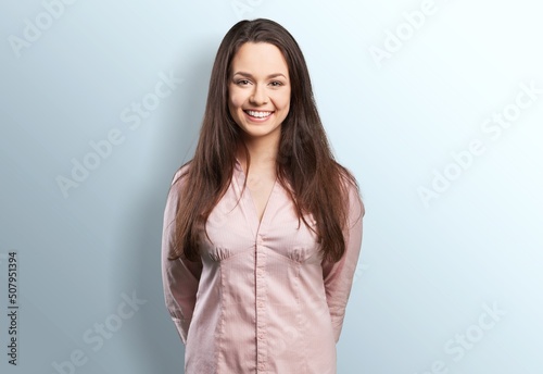 Young happy smiling woman in shirt with crossed arms over background