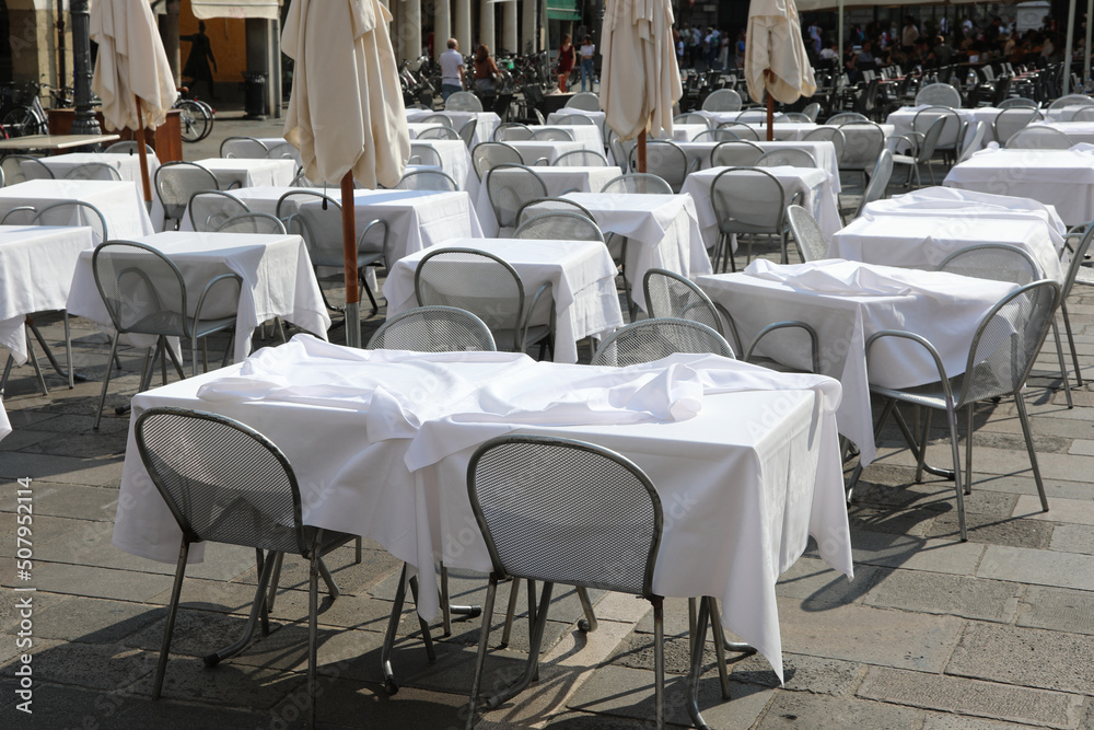 empty chairs and tables without customers in the alfresco bar of the square during the economic crisis caused by the coronavirus lockdowns