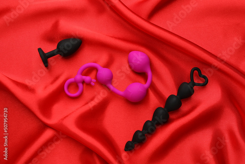 Sex toys on red fabric, flat lay