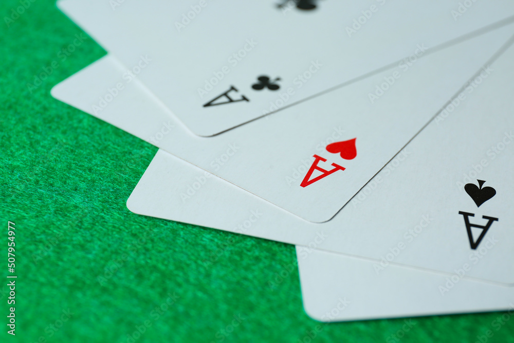 Playing cards with three of kind combination on green table, closeup Playing cards with three of kind combination on green table, closeup