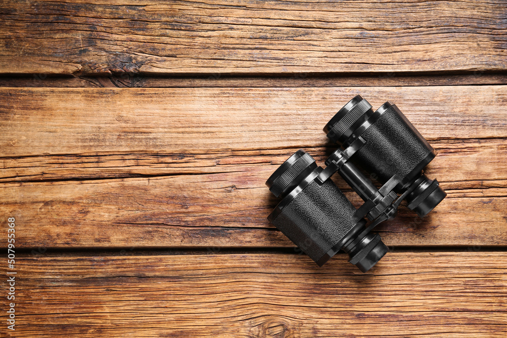 Binoculars on wooden table, top view. Space for text Binoculars on wooden table, top view. Space for text