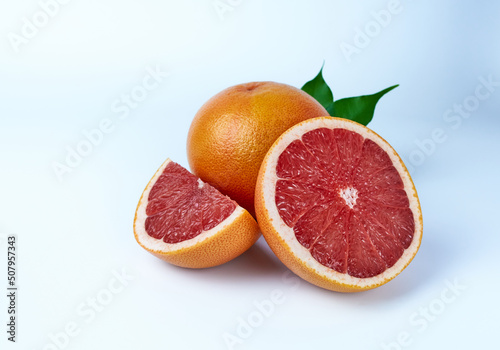 Grapefruit whole, cut in half and a quarter on a white background close-up.