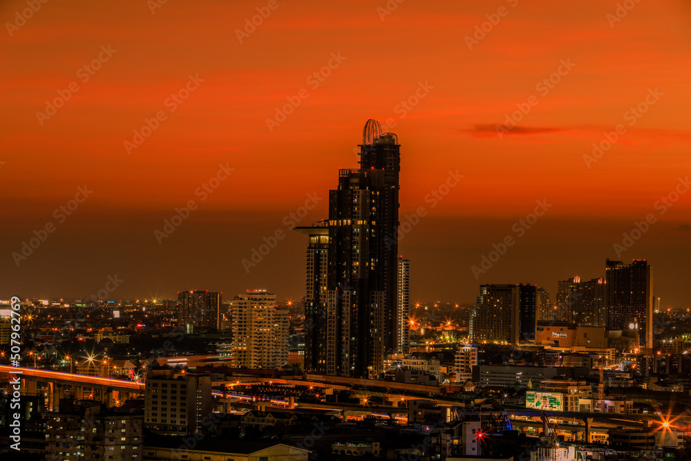 The high angle background of the city view with the secret light of the evening, blurring of night lights, showing the distribution of condominiums, dense homes in the capital community