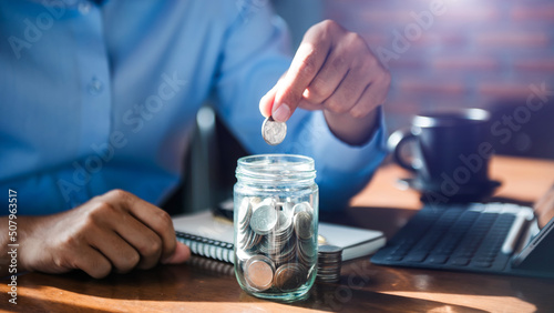 Hand putting mix coins and seed in clear bottle and business investment growth concept.