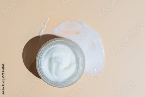 Skincare cosmetic cream or lotion swatch smear smudge on beige color background. White creamy hygiene beauty product in a jar. flat lay, copy space