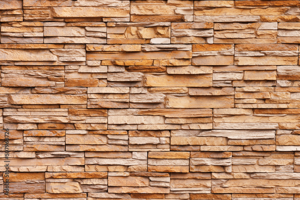Brick wall cladding with narrow natural stones of various sizes and shapes. Brick wall cladding with narrow natural stones of various sizes and shapes.