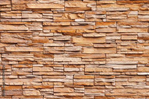 Brick wall cladding with narrow natural stones of various sizes and shapes.