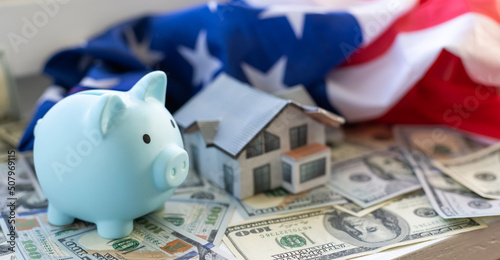 Golden Piggy Bank on Dollars with American Flag, paper house photo