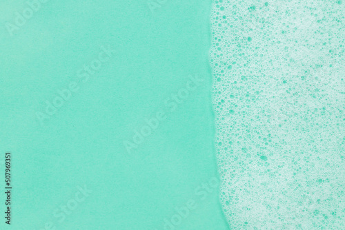 Soap foam overlying on the background of a turquoise water color