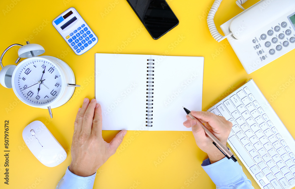 Office desk table with smartphone, laptop computer, cup of coffee and supplies. Top view with copy space, flat lay. Bank notebook with pen are on top of office desk table with computer tools. Office desk table with smartphone, laptop computer, cup of coffee and supplies. Top view with copy space, flat lay. Bank notebook with pen are on top of office desk table with computer tools.