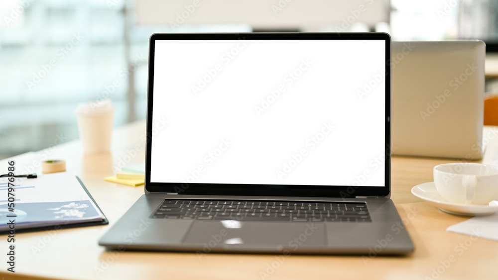 Notebook laptop computer white screen mockup on meeting table. close-up image Notebook laptop computer white screen mockup on meeting table. close-up image