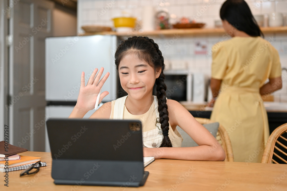 Pretty Asian young girl studying on online class via tablet computer Pretty Asian young girl studying on online class via tablet computer