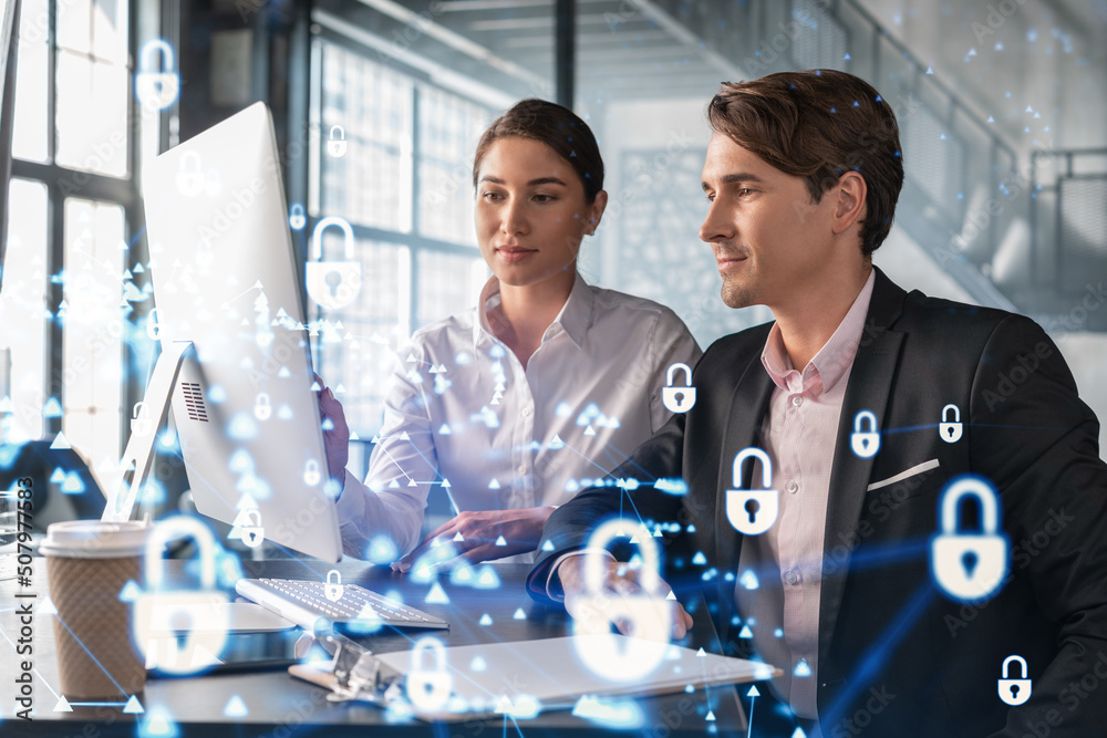 © VideoFlow - Businessman and businesswoman working together to protect clients confidential information and cyber security. IT hologram padlock icons over office background with panoramic windows.