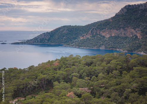 Fototapeta Naklejka Na Ścianę i Meble -  travel to Lagoon in Oludeniz, Fethiye, Turkey. beach near Darbogaz. Winter landscape with mountains, green forest, azure water, beach and cloudy sky