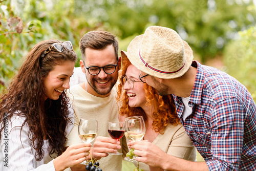 Wall Mural Happy friends having fun drinking wine at winery vineyard - Friendship concept w
