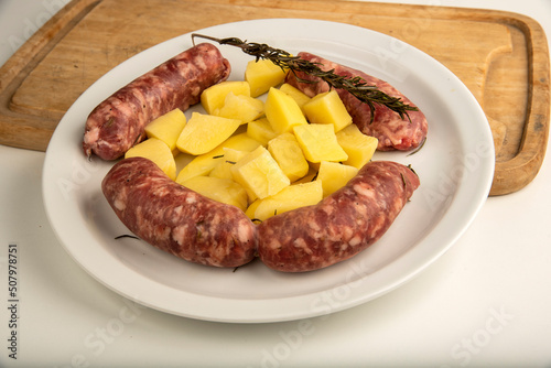 Sausages with fennel with potato garnish on a white plate