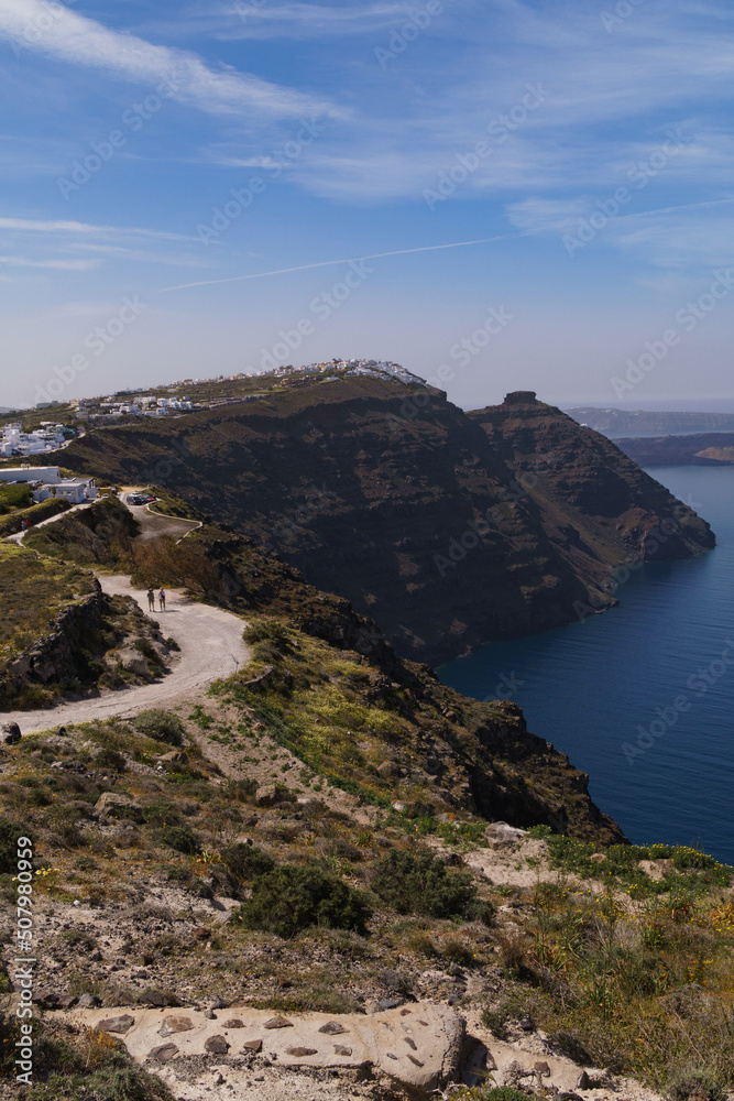 Coastal pathway leading to Imerovigli from North Santorini. Skaros rock can be seen in the distance. Portrait image.