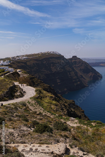 Coastal pathway leading to Imerovigli from North Santorini. Skaros rock can be seen in the distance. Portrait image.