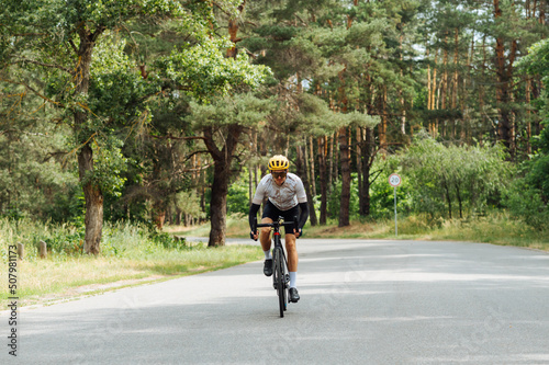 Wallpaper Mural Young man in sports equipment trains in the woods outside the city and rides on an asphalt road. Torontodigital.ca