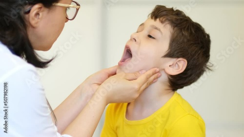 medical examination. Pediatrician feels the tonsils in a child with a sore throat and shows his tongue photo