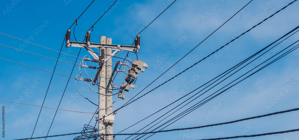tall electric poles with wires stretching obliquely in a photo frame against a blue sky background tall electric poles with wires stretching obliquely in a photo frame against a blue sky background