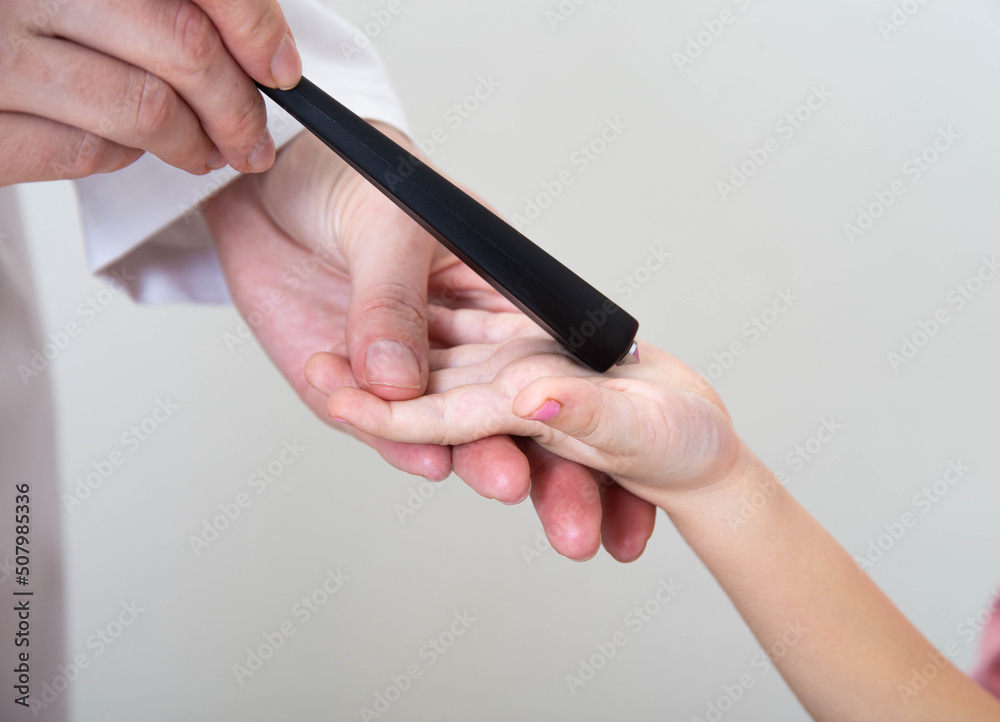 A neurologist examines a girl s palm chin reflex with a neurological hammer. Cervicocranialgia and oral automatism, close-up A neurologist examines a girl s palm chin reflex with a neurological hammer. Cervicocranialgia and oral automatism, close-up