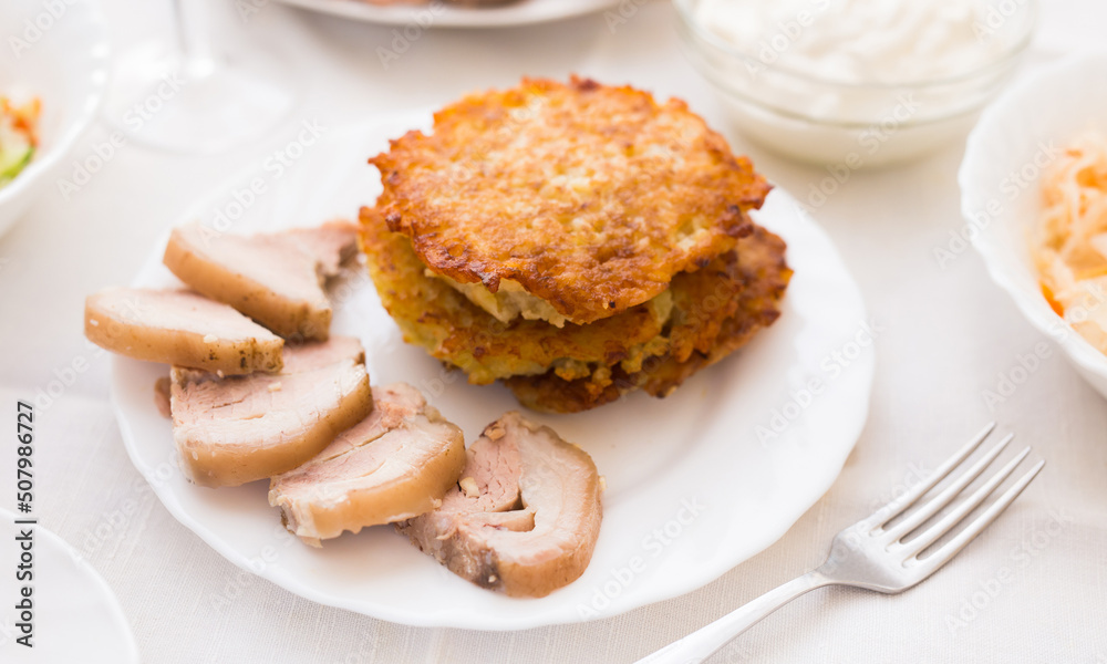 Potato pancakes with meat on white plate Potato pancakes with meat on white plate