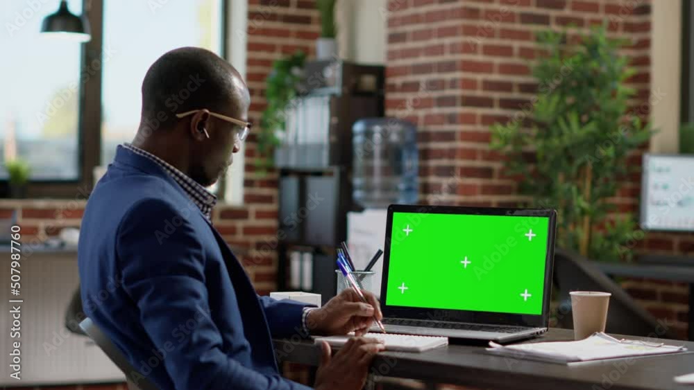 Office employee looking at laptop with greenscreen template, working in startup space. Sales consultant using isolated mockup background with chroma key display and blank copyspace. Office employee looking at laptop with greenscreen template, working in startup space. Sales consultant using isolated mockup background with chroma key display and blank copyspace.