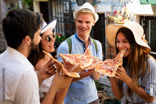 Group of friends eating pizza while traveling on vacation