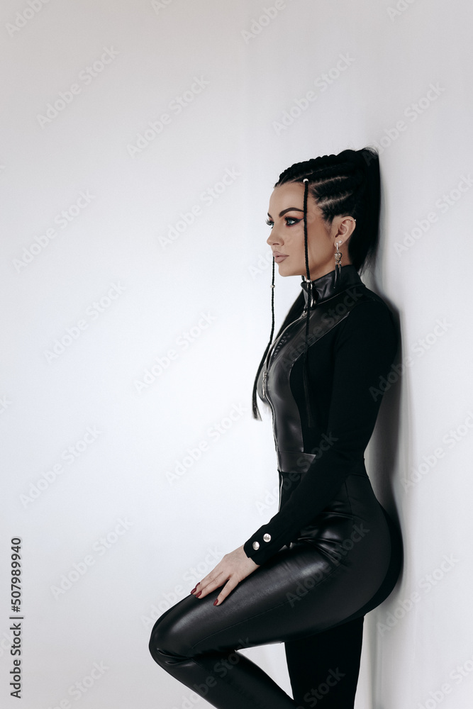 Sexy girl in a black latex suit on a gray background Stock Photo | Adobe  Stock