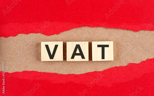Vat word on wooden cubes on red torn paper , financial concept background
