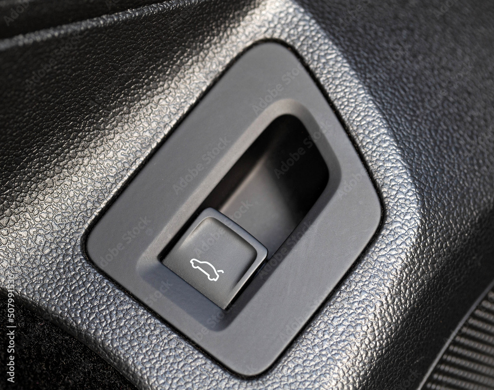 Black modern button to open the trunk in the car, macro Black modern button to open the trunk in the car, macro