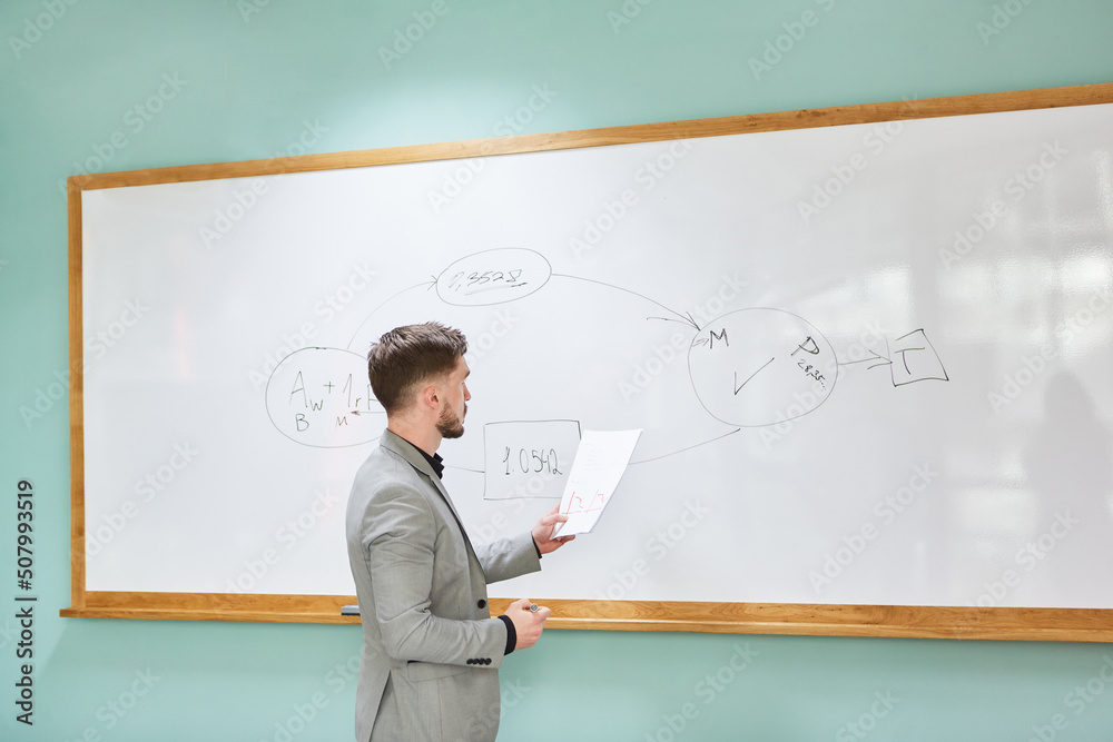 Junger Wissenschaftler mit Exposé am Whiteboard Junger Wissenschaftler mit Exposé am Whiteboard
