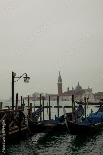 Gondolas in pier in foggy morning in venice. 