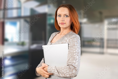 Happy professional business female writing in clipboard, working in modern office. Professional concept