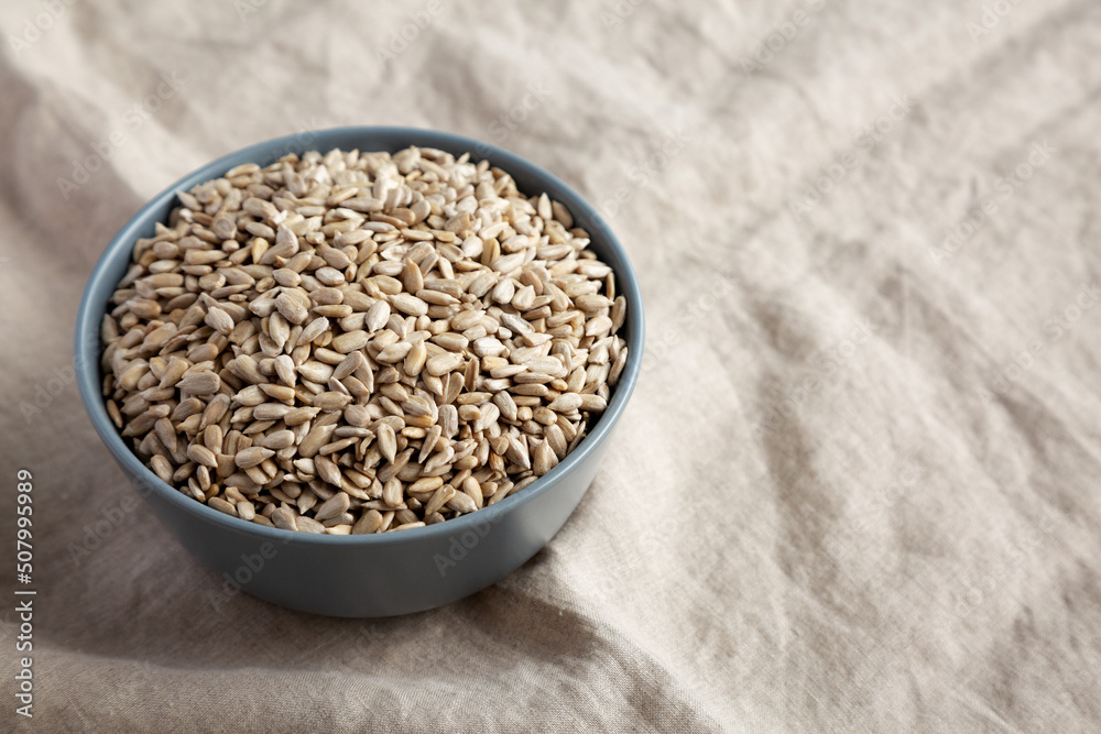Raw Organic Sunflower Seed Kernels in a Blue Bowl, side view. Space for text. Raw Organic Sunflower Seed Kernels in a Blue Bowl, side view. Space for text.