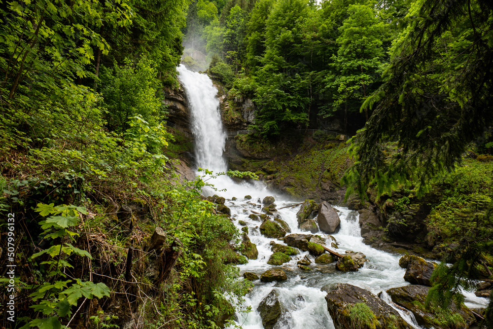 Beautifull large waterfall in the Swiss Alps. Sunny summer day, green nature, no people
