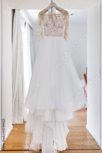 Wedding dress hanging on the door in the white room