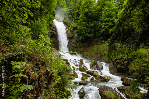 Beautifull large waterfall in the Swiss Alps. Sunny summer day, green nature, no people